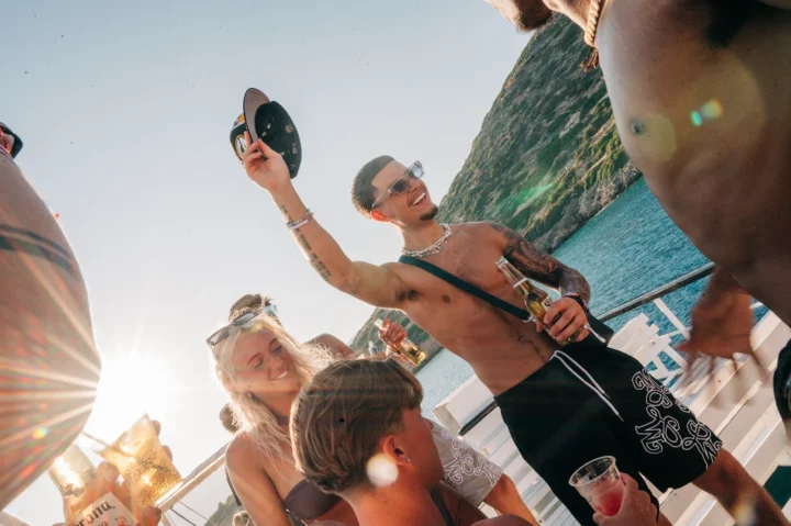 Sun shining, drinks in hand and tunes pumping – the Malia Booze Cruise crew living it up on deck with non-stop party vibes.