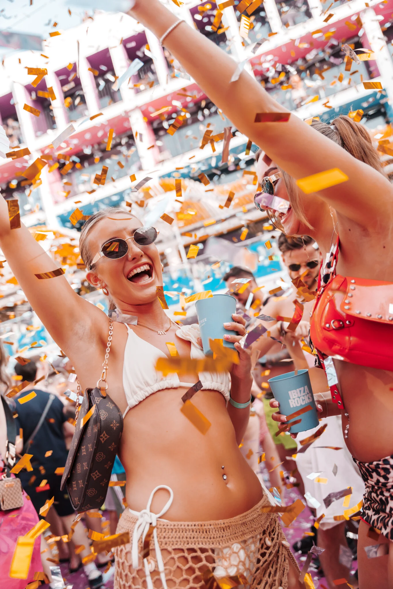 Partygoers celebrating at LoveJuice Ibiza, confetti flying, drinks in hand and the crowd buzzing with summer energy.