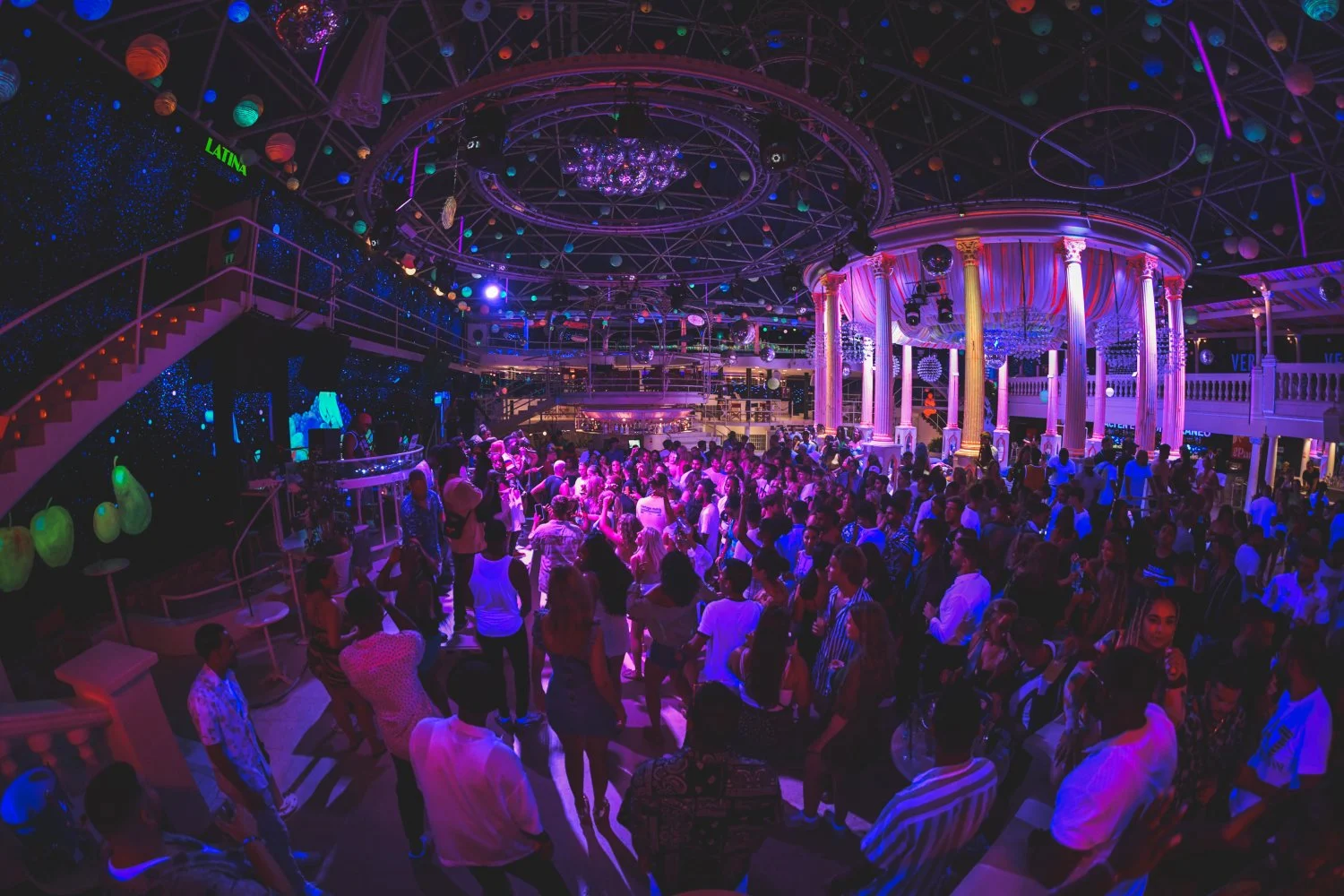 Party crowd at Es Paradis Ibiza under neon lights and vibrant decor, dancing all night in the island’s iconic club.