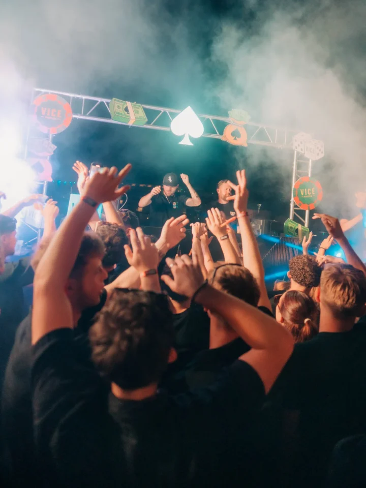 Crowd with hands raised enjoying DJs performing on stage at the Vice Rooftop Party event in Ayia Napa.