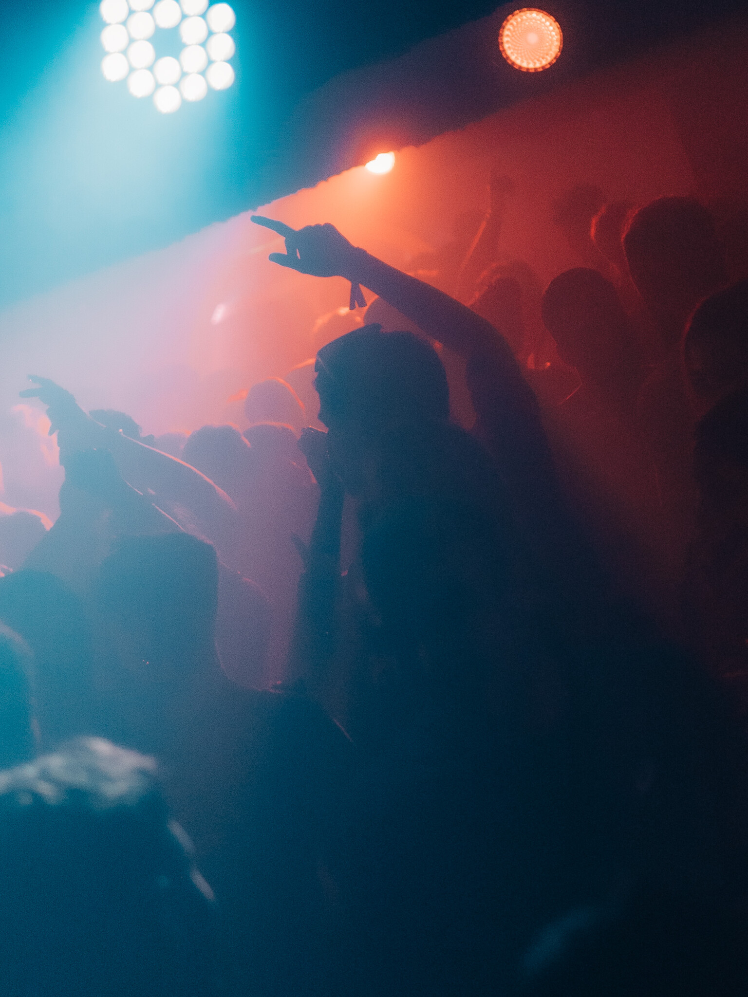Crowd dancing with hands raised under red and blue lights at the Lovejuice Residency event in Ayia Napa.