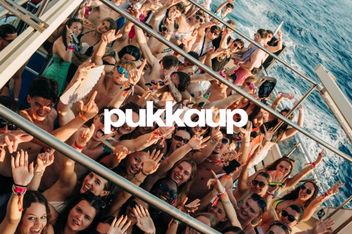 Group Hands Raised In The Air with Blue Sea On Party Boat