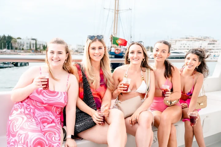 Group of girls enjoying drinks on a boat trip during a holiday in Albufeira.