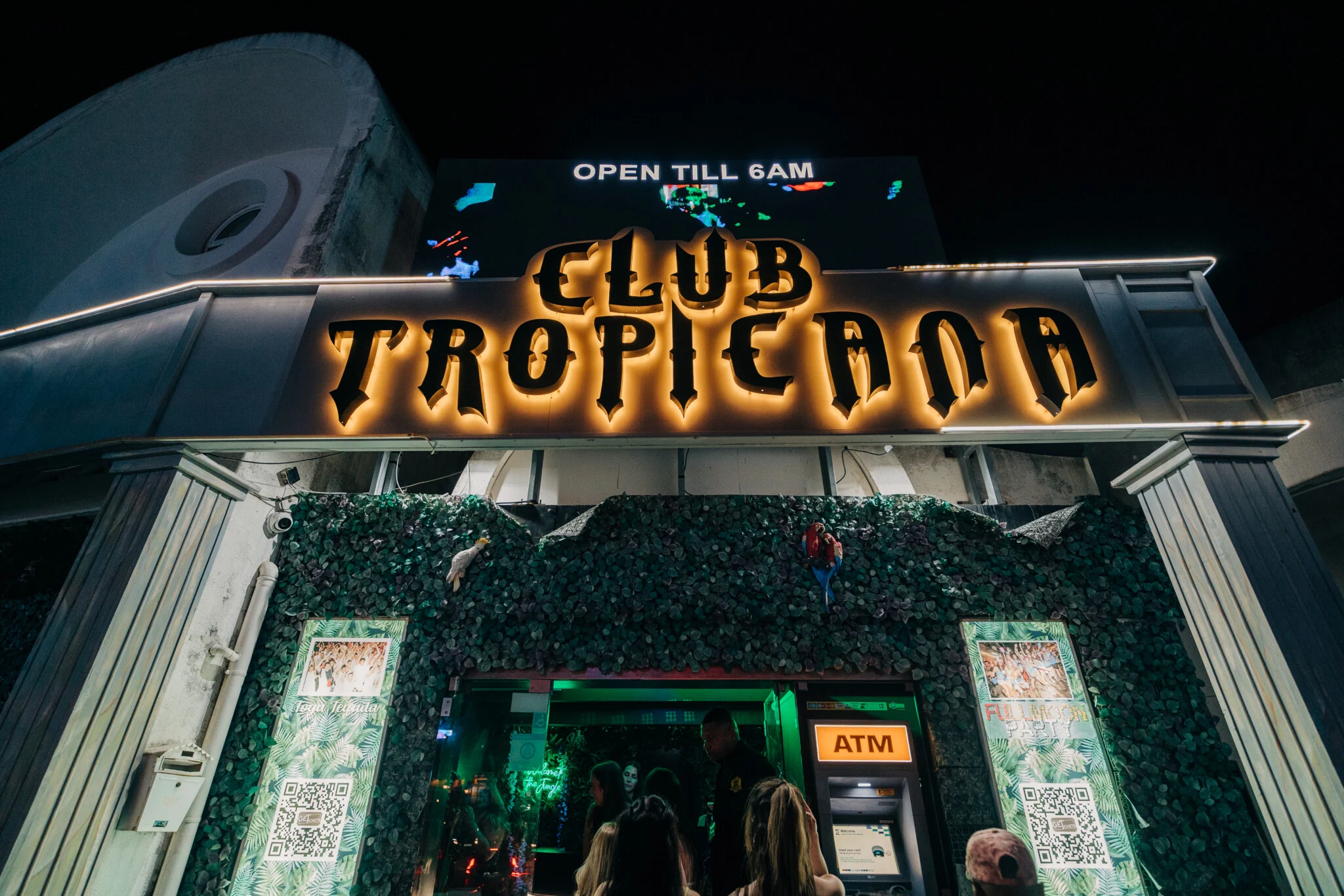 Entrance of Club Tropicana Albufeira glowing at night as partygoers head inside for another huge summer night out.