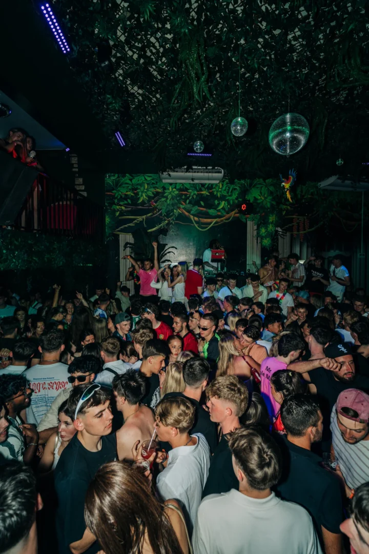 Club Tropicana Albufeira packed with partygoers dancing under jungle lights and disco balls to summer anthems.