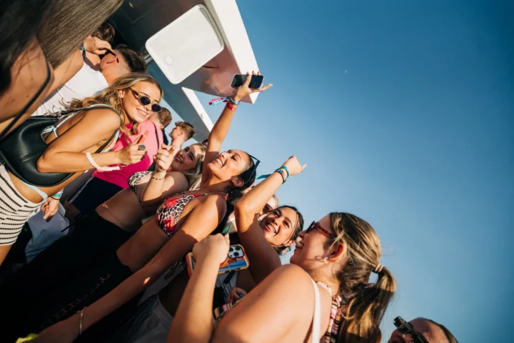 Girls smiling, dancing and raising their hands while celebrating at the Albufeira Boat Party, enjoying the sunshine, music and holiday vibes.
