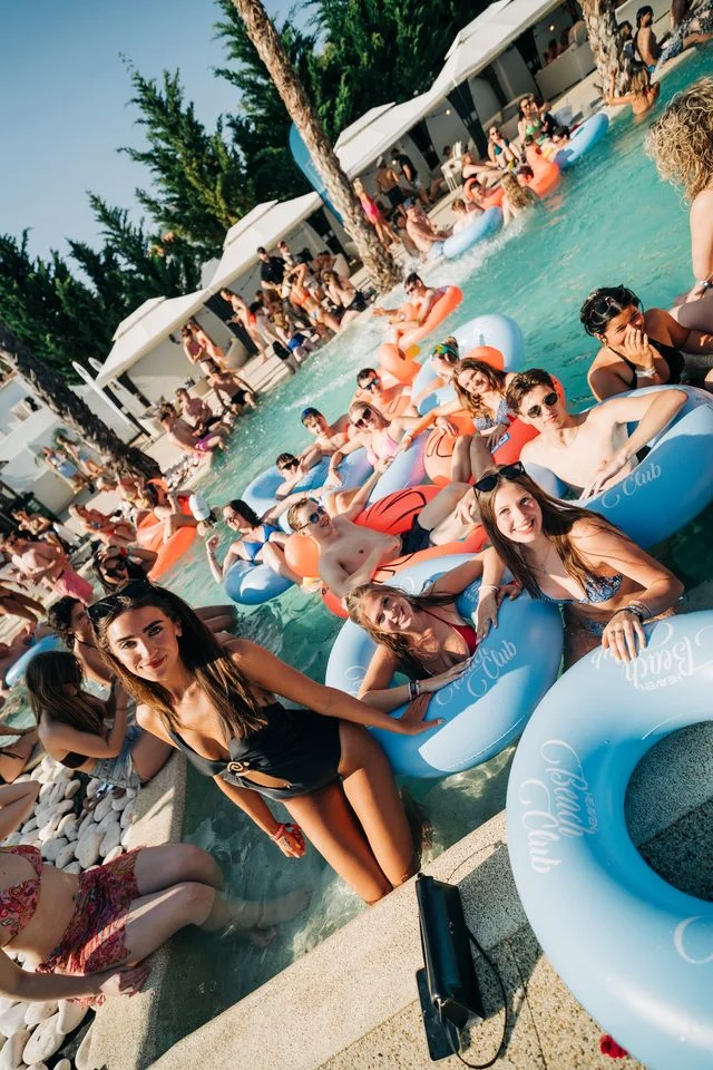 Crowds chilling on inflatables and posing poolside under the sun at the ultimate Albufeira Pool Party.