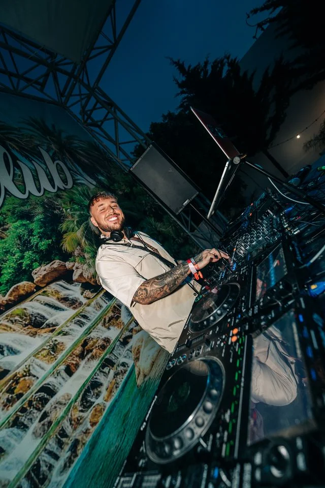 DJ spinning tracks with a smile at Agenda Beach Club Party in Albufeira, keeping the crowd buzzing all night long.