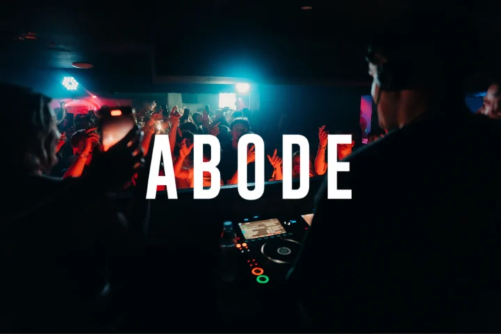 Crowd partying at Ayia Napa Abode event with DJs performing in a packed nightclub atmosphere under red and blue lights