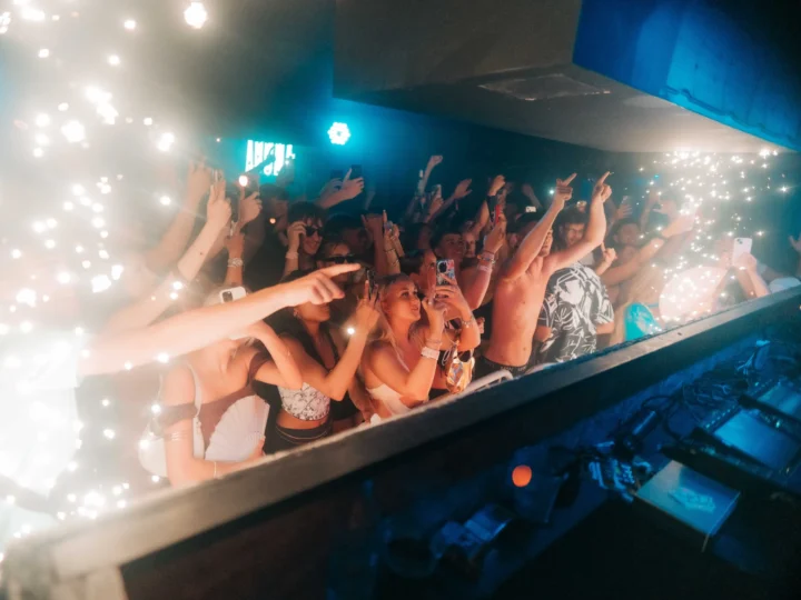 Crowd at Ayia Napa nightclub partying with sparklers and lights while fans capture the moment on their phones