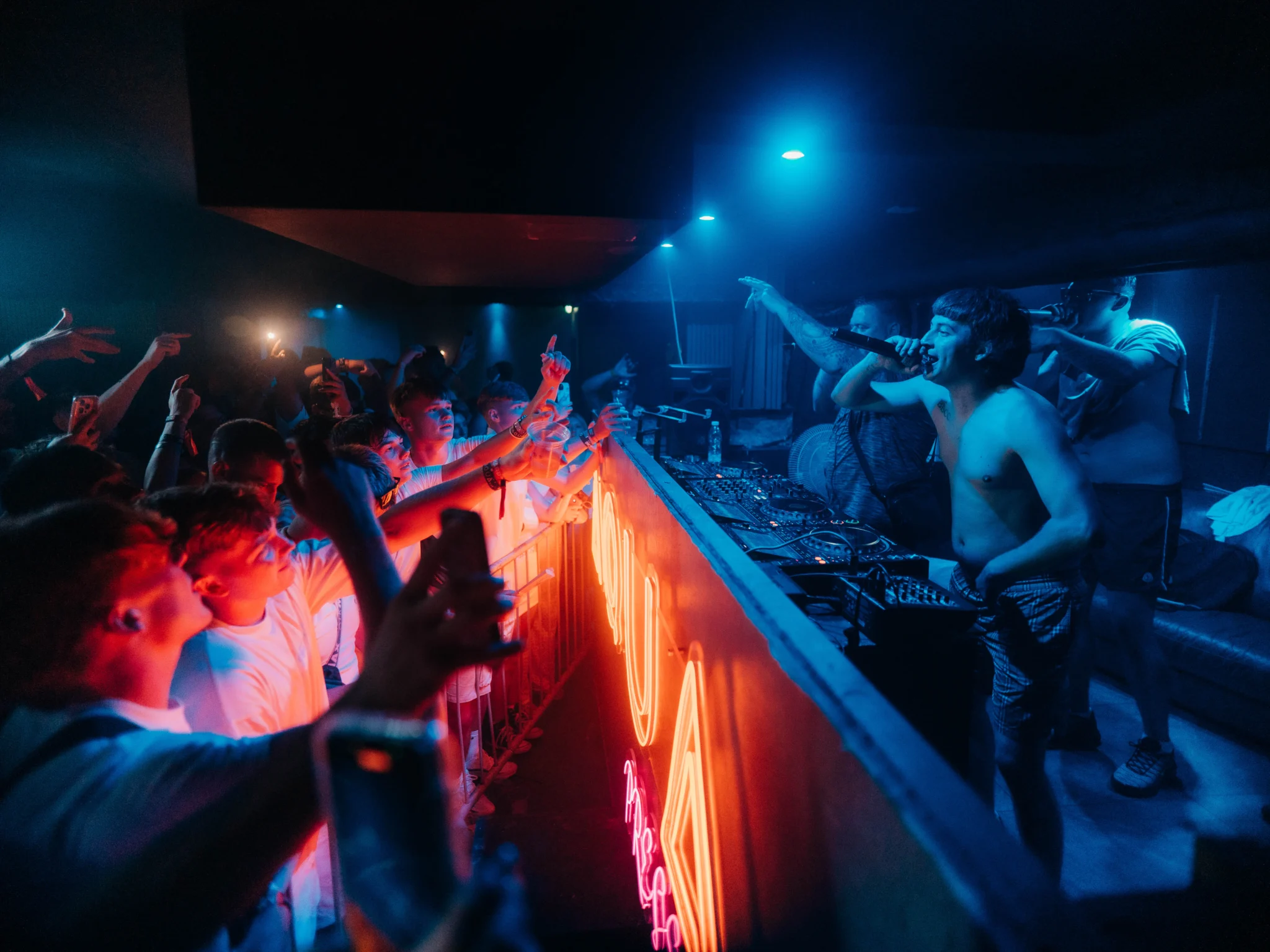 Packed Ayia Napa nightclub with DJs and MCs performing live as the crowd parties under blue and neon lights