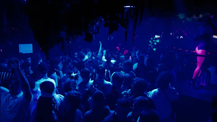 Packed dancefloor at Opium Barcelona nightclub with hands in the air, deep blue lights and full crowd energy all night long