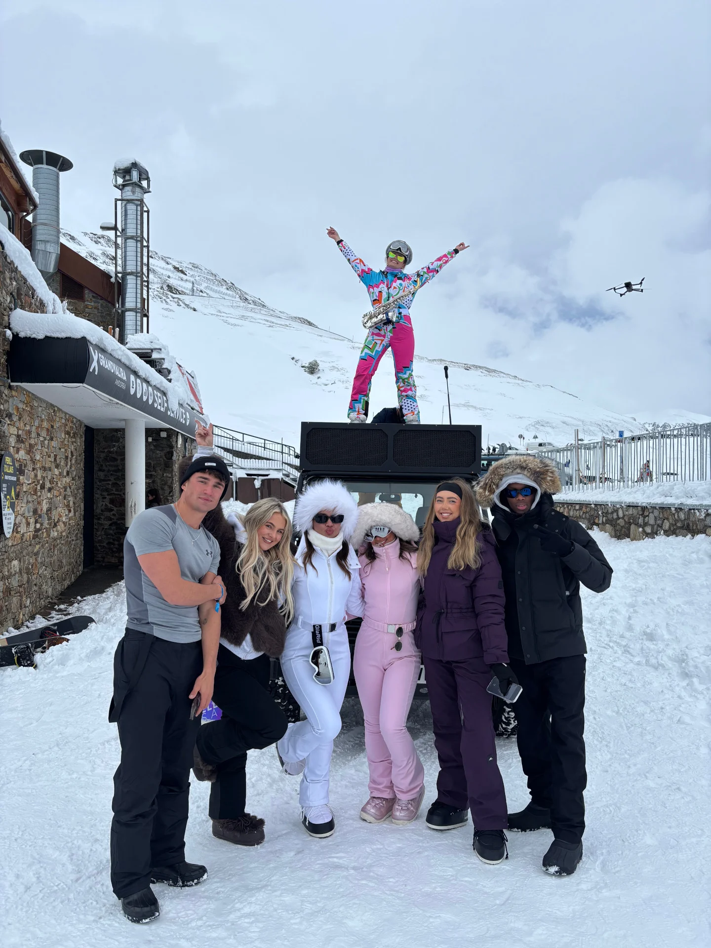 Girls posing on the slopes in full ski gear, showing off bright outfits before another big après session in the mountains.